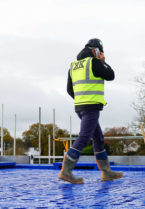 Man in hi-vis walking on blue QDeck safety decking